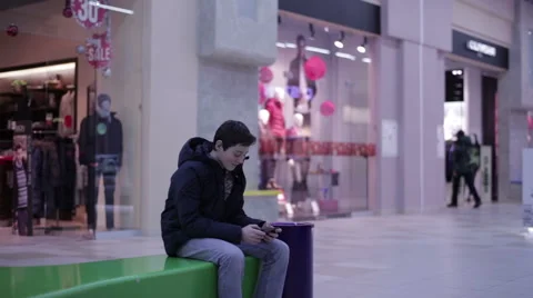 Teen sitting on a bench and playing phone Stock Footage 59790120