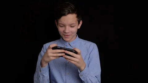 Teen smiling and using mobile phone on black background. Stock Footage 124384293