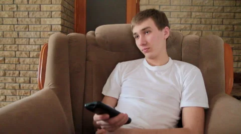 Teen on a sofa with remote control 動画素材 1183519