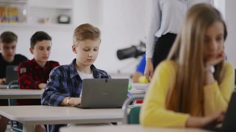Teen students learning programming in a computer class,. Focus on a cute blonde Stock Footage 111969973