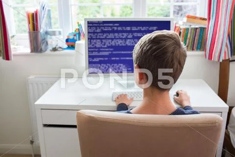 Teenage Boy In Bedroom Writing Computer Code Stock Photos