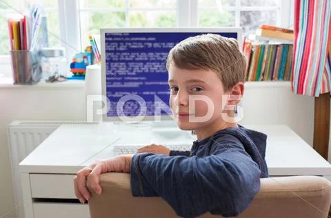Teenage Boy In Bedroom Writing Computer Code Stock Photos