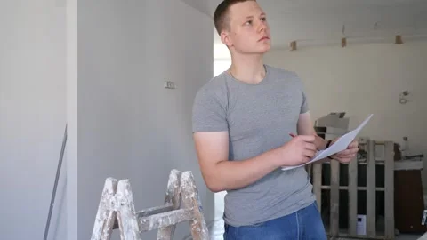 Teenage boy checking documents in construction site during workday on part-time Stock Footage 263691925