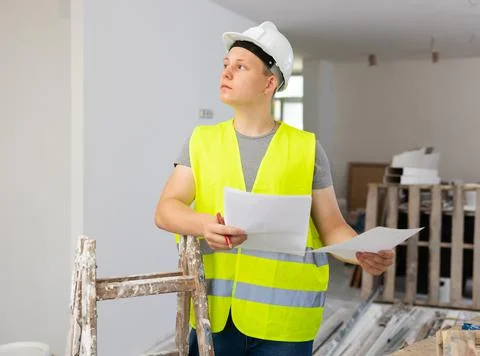 Teenage boy checking documents in construction site Stock Photos
