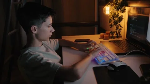 Teenage Boy Coding on Laptop in Dark Room at Night 库存影片 344967857