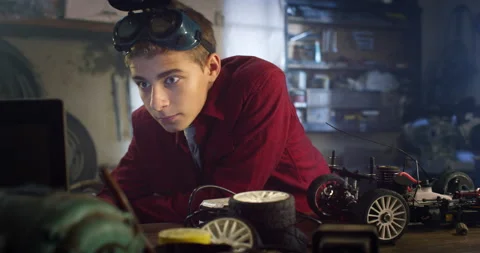 Teenage Boy Constructing a Functional Toy Car in Home Workshop Stock Footage 236990899