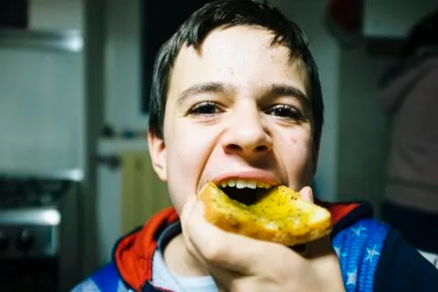 Teenage boy eats slice of bread with jam for snack Stock Photos
