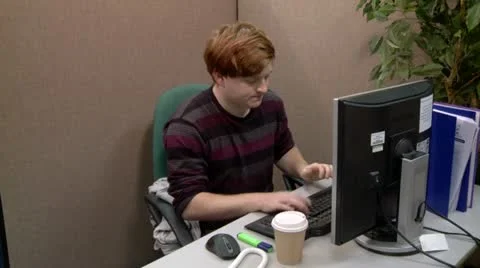 Teenage boy getting angry with computer in office Vídeos de archivo 12401918