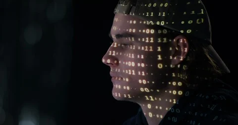 Teenage boy hacking with matrix projected on his face Stock Footage 101683372