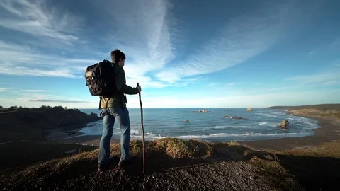 Teenage boy hiking trail on Pacific Ocean at sunset, Oregon Stock Footage