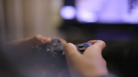 Person playing video games with controller on computer Stock Photo