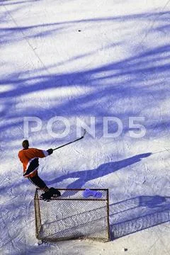 Teenage Boy Playing Ice Hockey On The Frozen Assiniboine River. The Forks,