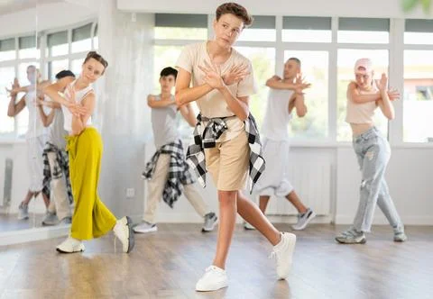 Teenage boy practicing basic hip hop moves in training hall 写真素材