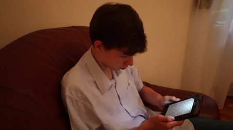 Teenage boy reading an eBook at home education, gadget, electronic device Stock Footage 40687853