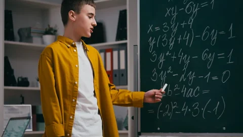 Teenage boy student explaining the solution to math problem near chalkboard Stock Footage 251805538
