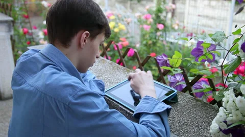 Teenage boy with tablet computer in the garden, young male student Stock Footage 39655661