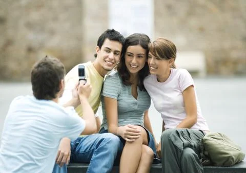 Teenage boy taking photo of friends with cell phone Stock Photos