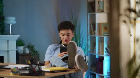 Teenage boy texting on cellphone instead of doing homework, procrastination Stock Footage 331865636