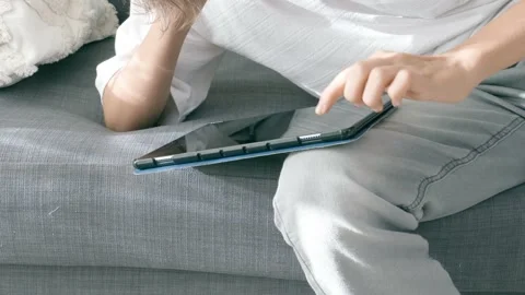 Teenage boy using digital tablet computer at home couch. Child looking at gadget Stock Footage 221362308