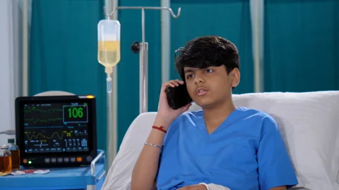 A teenage boy is using a smartphone while he is in the hospital - patient in ... Stock Footage 241912860