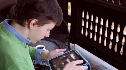 Teenage boy using a tablet computer, young man playing games on a terrace Stock Footage 36329016