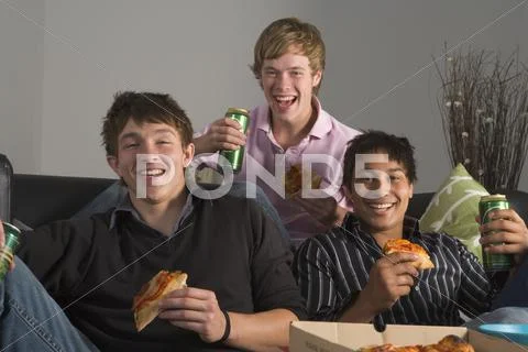 Teenage boys eating pizza Stock Photos