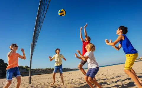 Teenage boys playing volleyball on the beach Stock Photos
