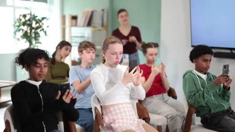 Teenage children scan the qr code on the presentation screen to get additional Stock Footage 341380486