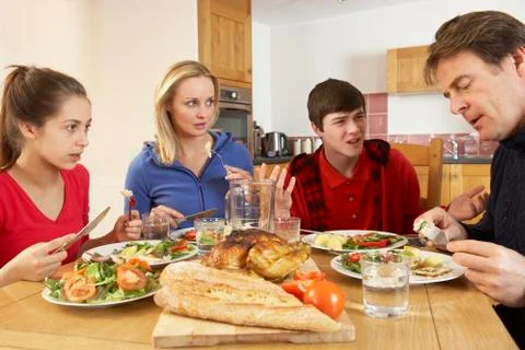 Teenage Family Having Argument Whilst Eating Lunch Together In Kitchen Stock Photos