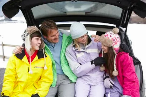 Teenage Family Sitting In Boot Of Car Wearing Winter Clothes Stock Photos