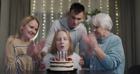 A teenage girl blows out the candles on ... | Stock Video | Pond5