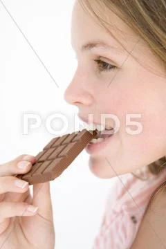 Teenage girl eating chocolate bar Stock Photos