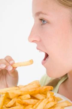 Teenage girl eating French fries Stock Photos