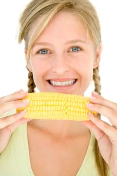 Teenage girl holding corn on cob and smiling Stock Photos