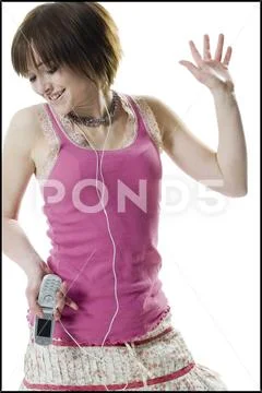 Teenage girl holding a mobile phone and listening to music Stock Photos