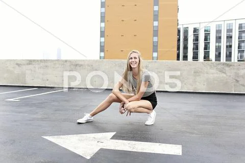 Teenage girl posing on urban rooftop parking lot Stock Photos