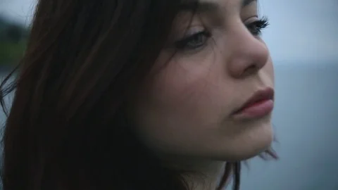 Teenage girl sad, alone, in front of a lake Stock Footage