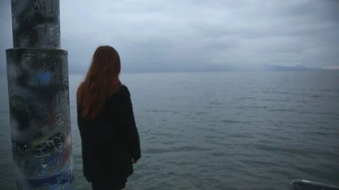 Teenage girl sad, alone, in front of a lake Stock Footage