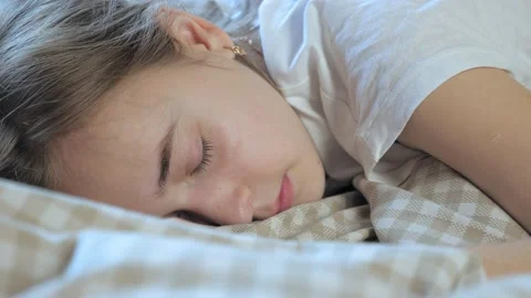 A teenage girl is sleeping in her bed. T... | Stock Video | Pond5