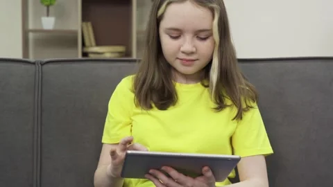 A teenage girl using tablet computer at home Stock Footage 170552051