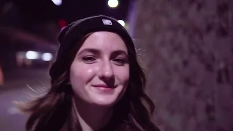 Teenage girl walking along night city street Stock Footage
