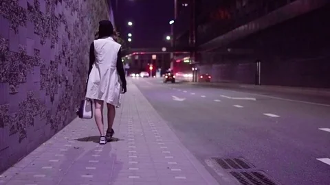 Teenage girl walking in night city Stock Footage