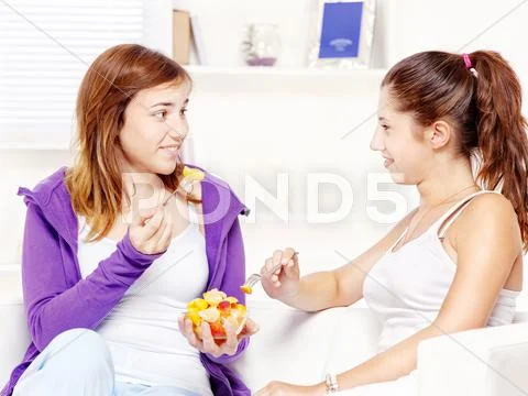 Teenage girls chating and eating fruit Stock Photos