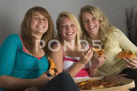 Teenage girls eating pizza Stock Photos