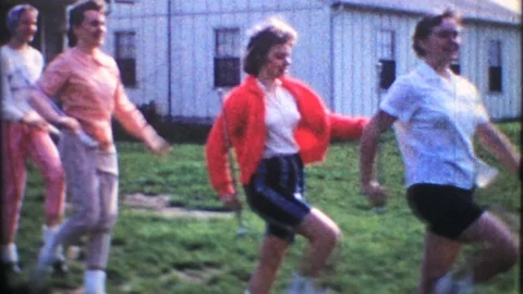Teenage girls practice baton twirling in backyard 1950s vintage home movie 3993 Stock Footage