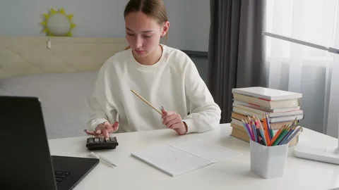 Teenage student doing homework using calculator and laptop Video stock 315175202