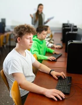 Teenage student learning basics of programming in computer college Stock Photos