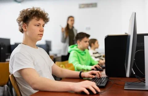 Teenage student learning basics of programming in computer college Stock Photos