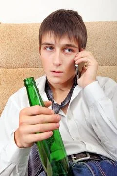 Teenager with a Beer and Cellphone Teenager with Bottle of the Beer and Ce... Stock Photos