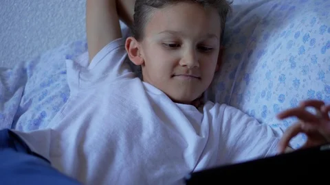 Teenager boy browsing social network on tablet and smiling Stock Footage 106978286